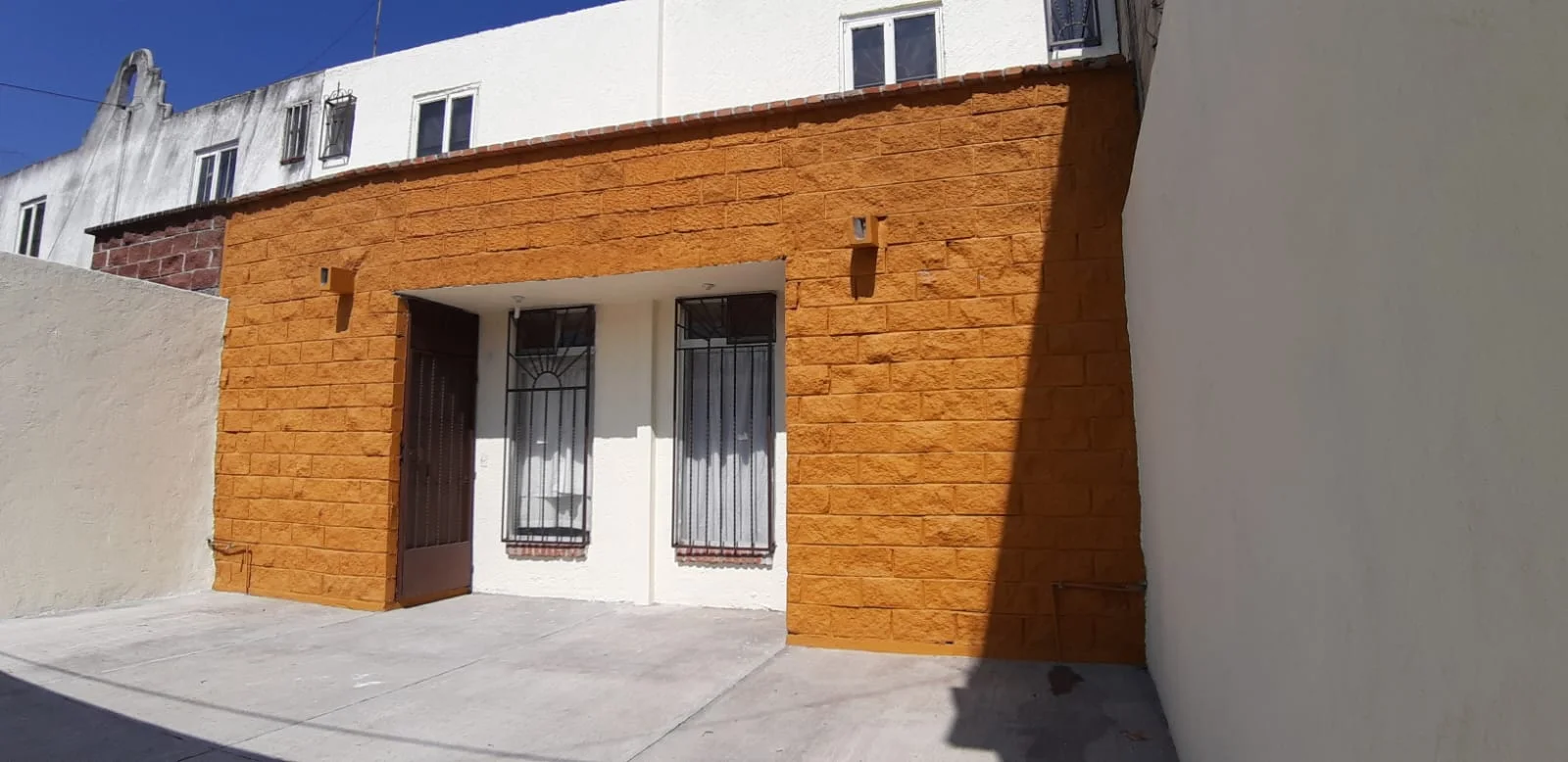 Detalle de la fachada terminada con revestimiento en tono ocre