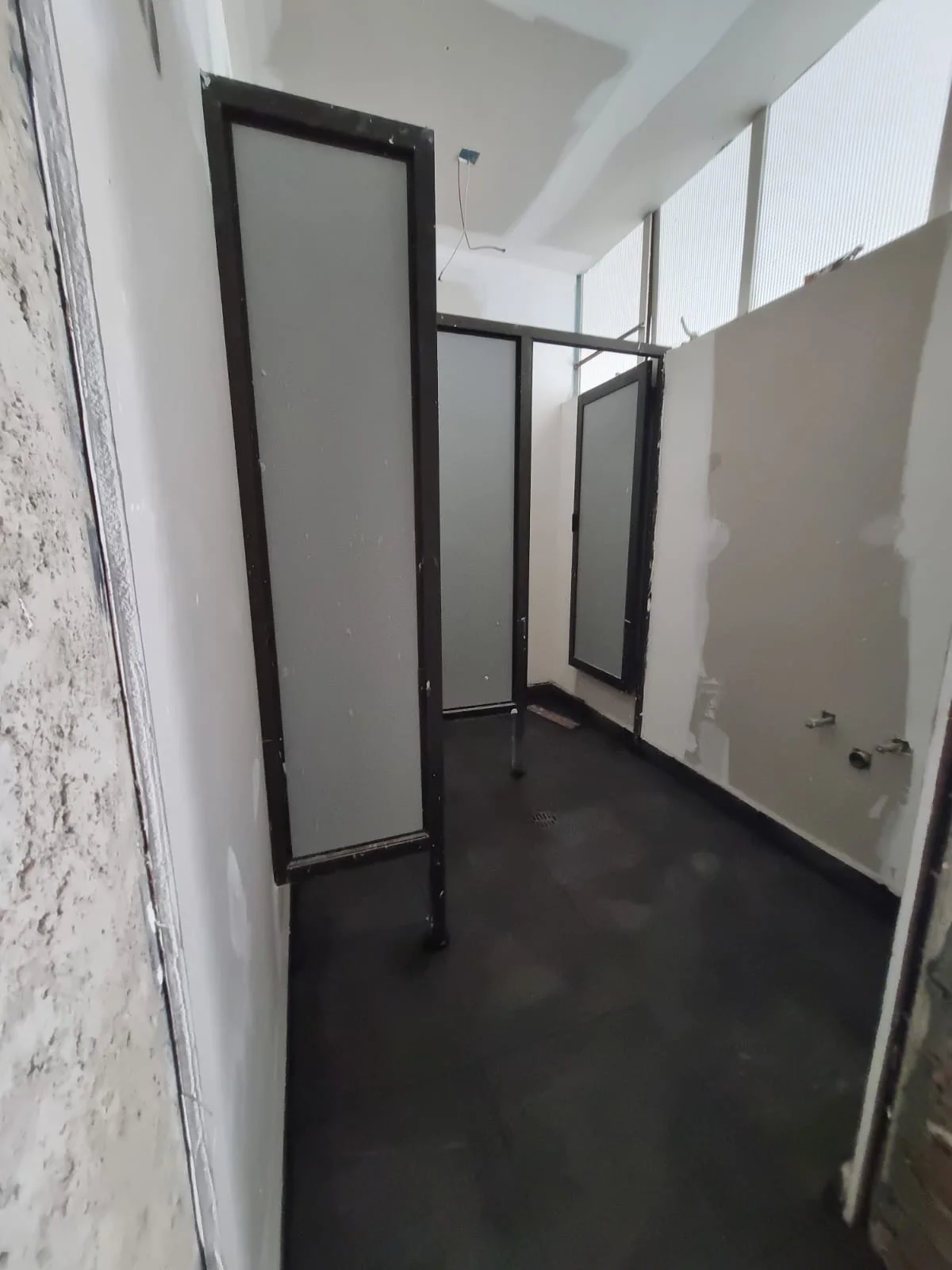 Área de lavabo durante la obra con divisiones y acabados en proceso