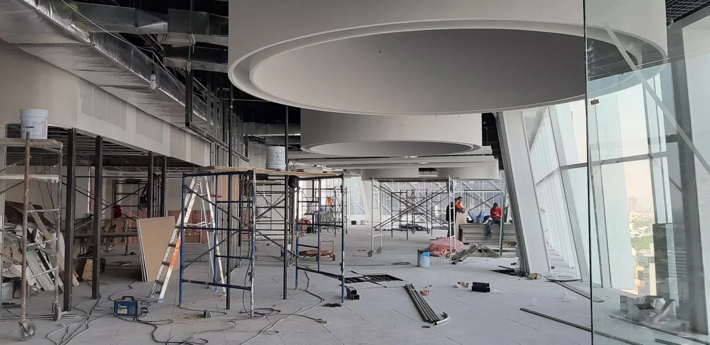 Sala de reuniones durante la obra, con plafones e instalaciones en proceso