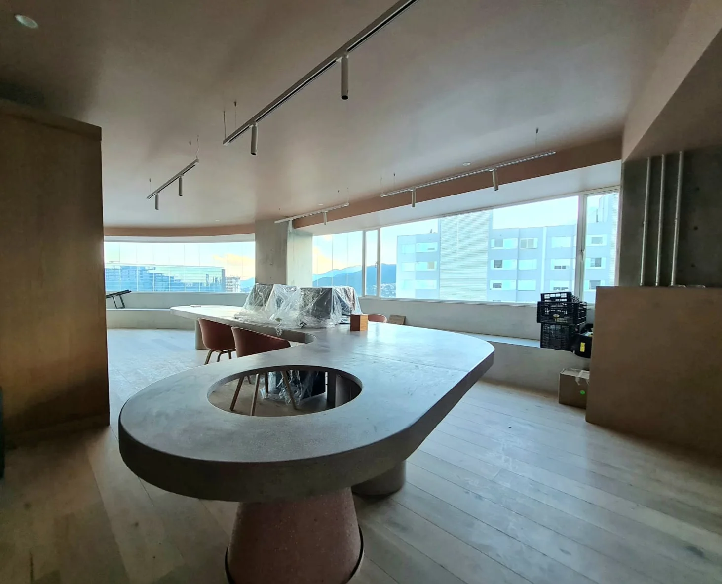 Detalle de mesa circular y acabados de madera junto a los ventanales