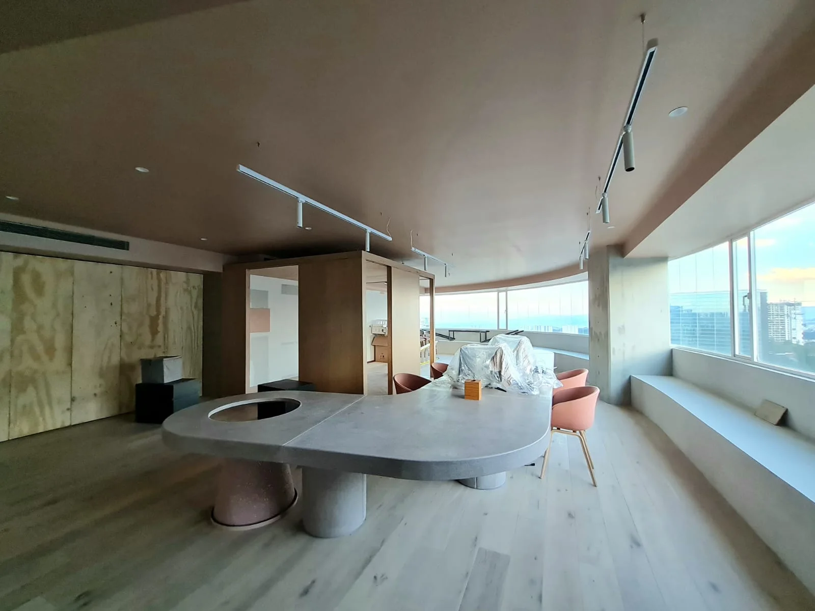 Vista del espacio común con mesa circular y revestimientos de madera