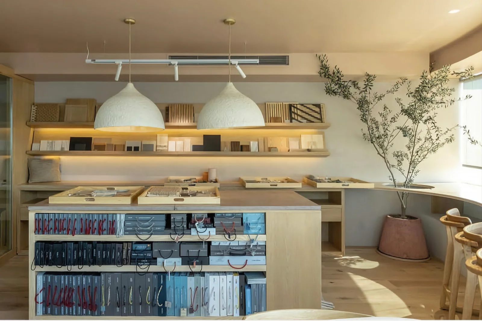 Barra de cafetería con estanterías, iluminación colgante y vegetación